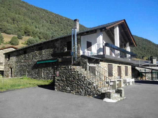 een stenen gebouw met een balkon aan de zijkant bij Borda Cortals de Sispony in La Massana
