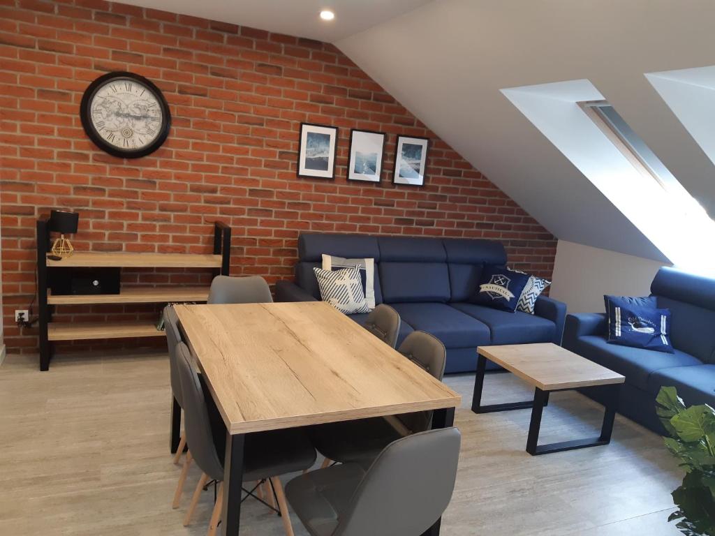 a living room with a table and a blue couch at Apartamenty Platinum 2 in Łukęcin