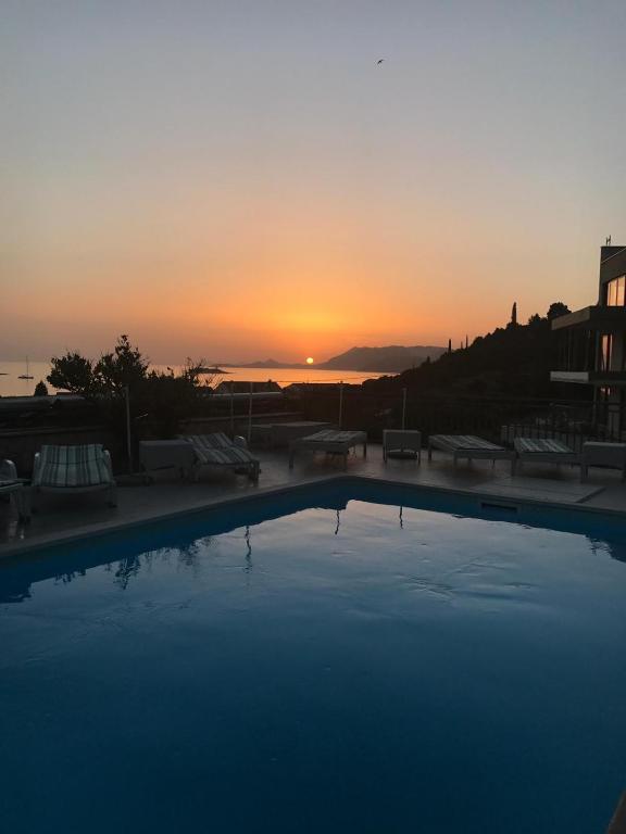 a large swimming pool with a sunset in the background at Guest House Villa Bellevue 1 in Cavtat
