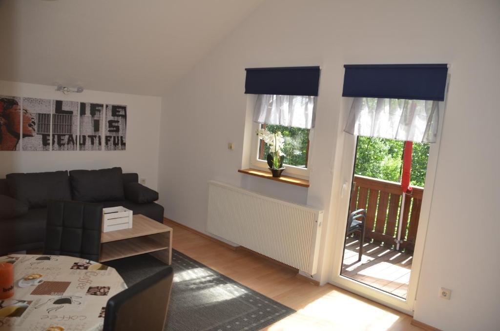 ein Wohnzimmer mit einem Sofa und einem Fenster in der Unterkunft Ferienwohnung Wildgatter in Grafenwiesen