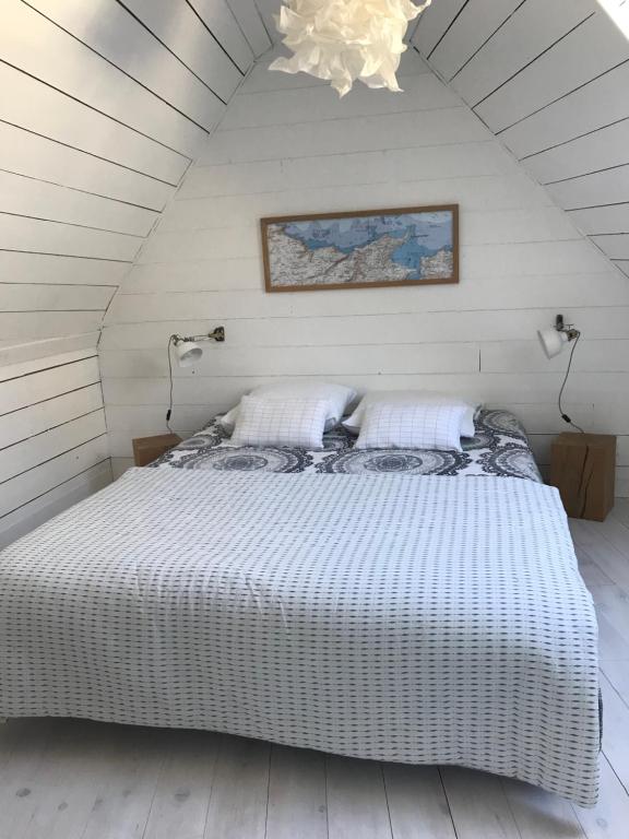 a bedroom with a large white bed in a attic at White and Sea Lodge in Locquirec