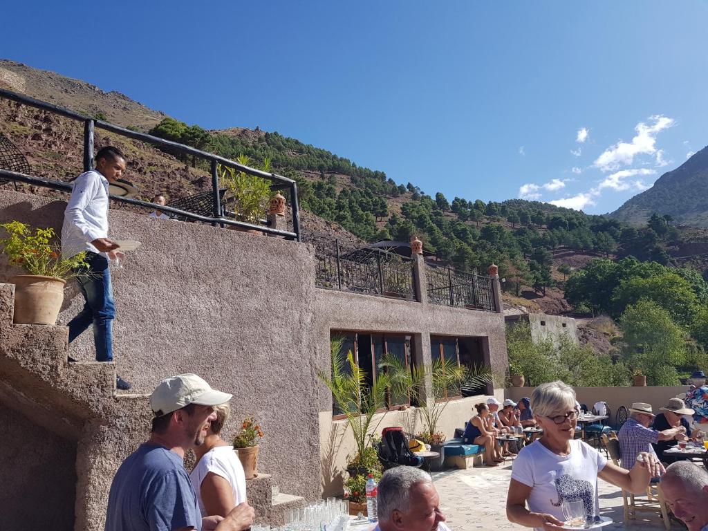 a group of people sitting on the side of a building at Toubkal Garden in Imlil