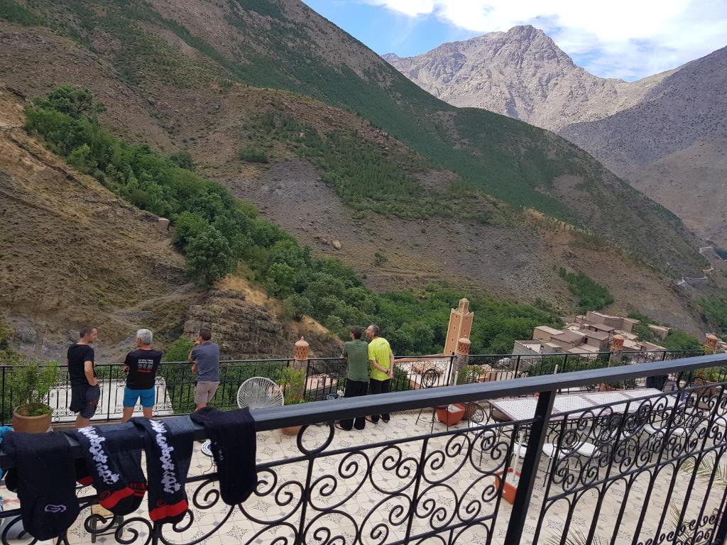 a group of people standing on a balcony looking at a mountain at Toubkal Garden in Imlil