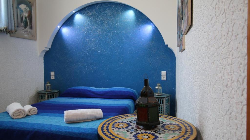 a blue room with a bed and a table with a bottle of wine at Riad Les Chtis D'Agadir in Agadir