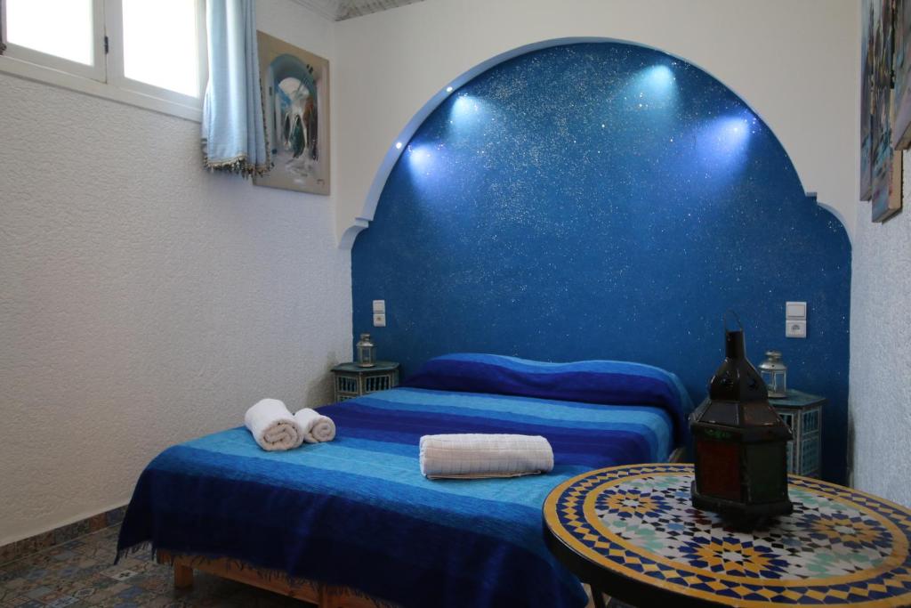 a blue bedroom with two beds and a table at Riad Les Chtis D'Agadir in Agadir