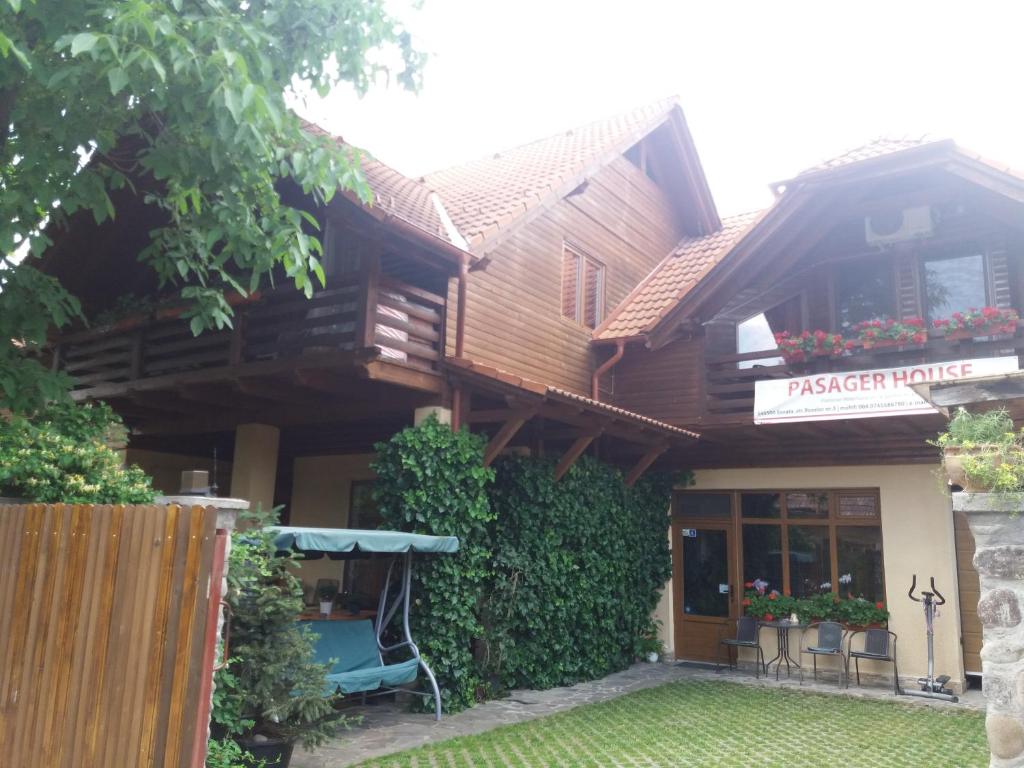 une maison en bois avec un panneau à l'avant dans l'établissement Pasager House, à Sovata