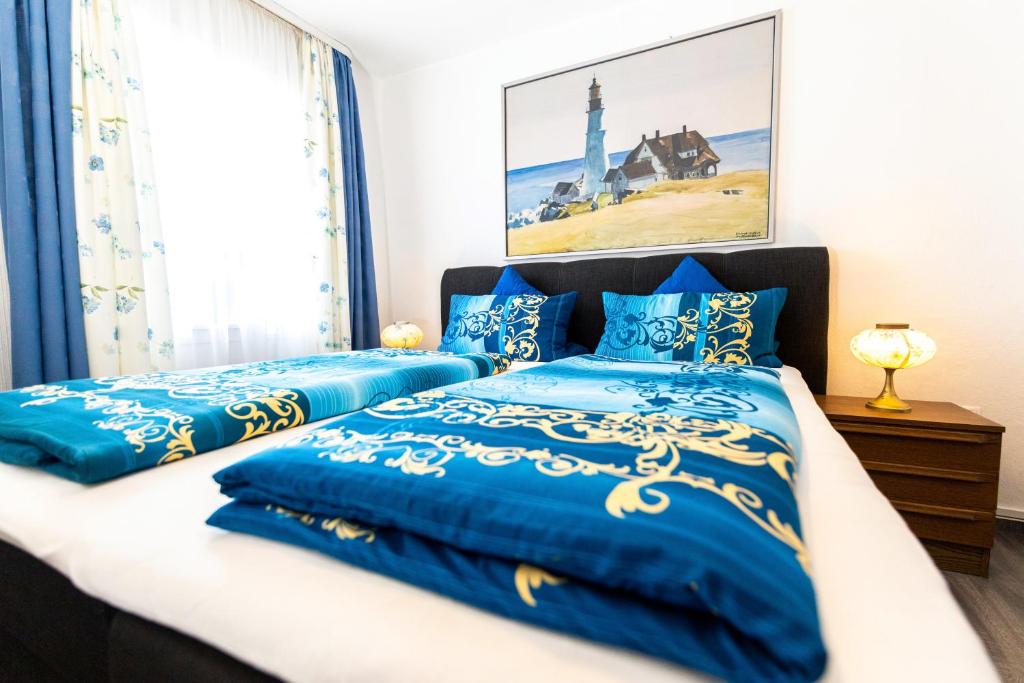 a bedroom with two beds with blue comforters at Gasthaus Tannenhof in Lütz
