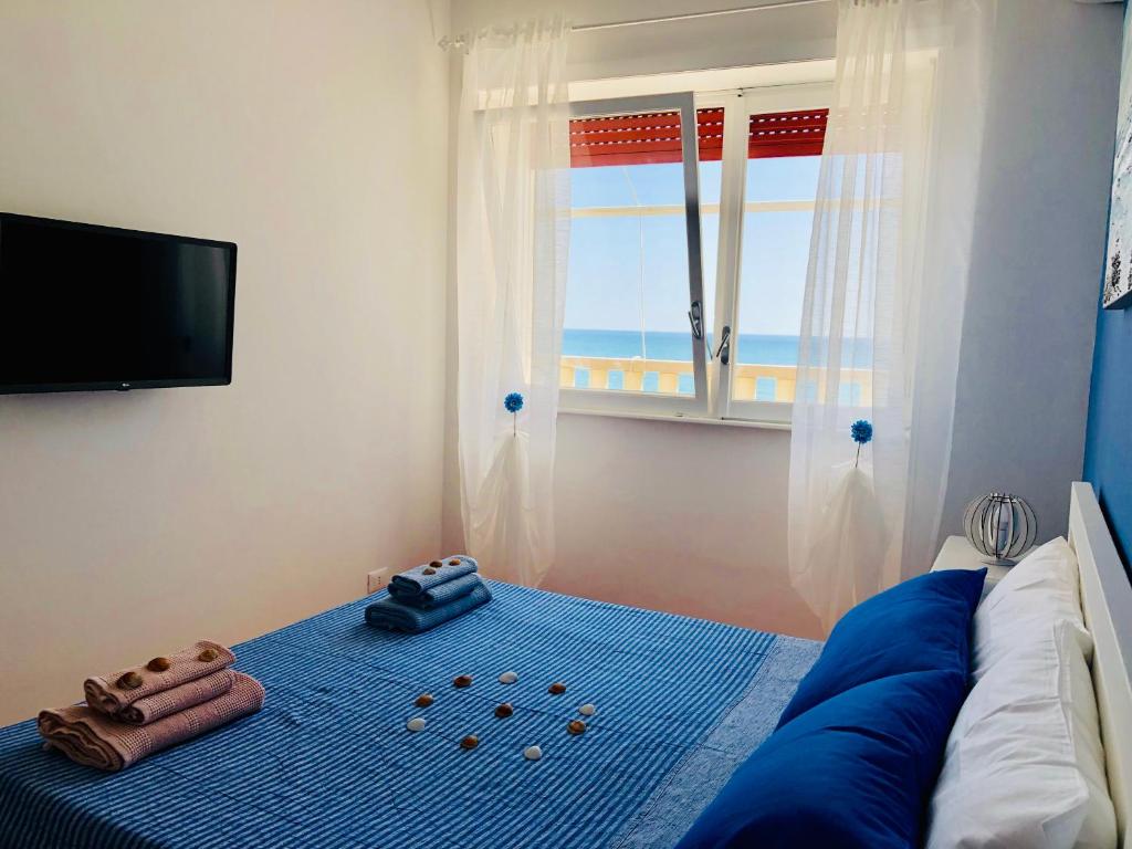 um quarto com uma cama com um cobertor azul e uma televisão em T-Village502 em Anzio