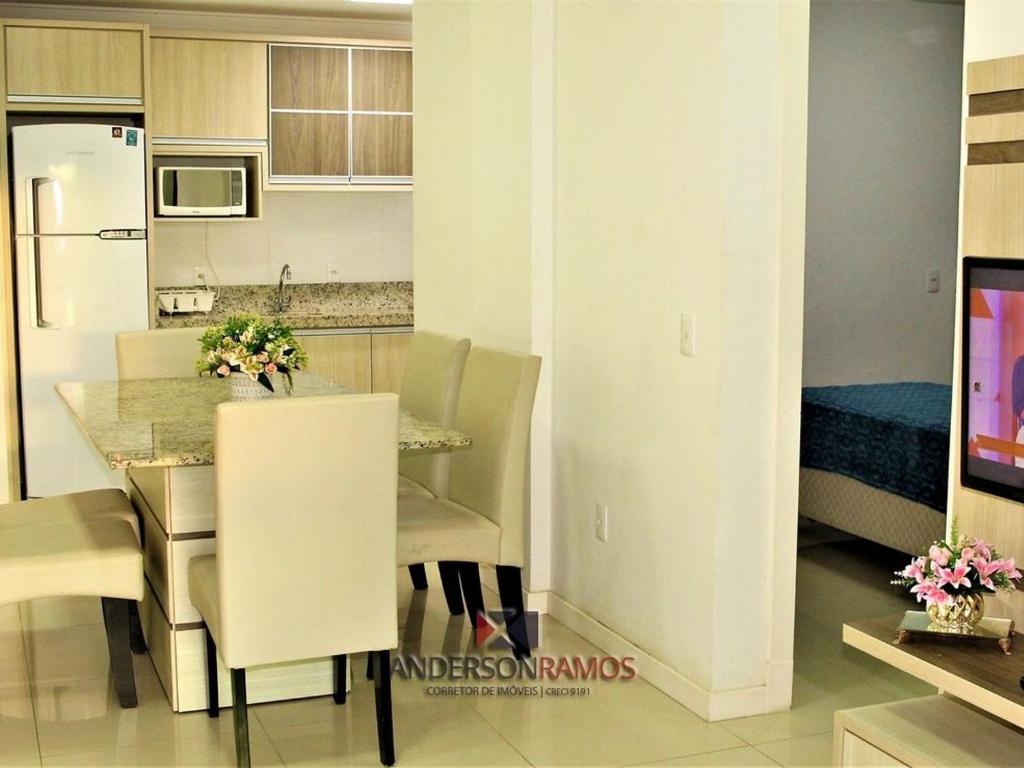 cocina y comedor con mesa y sillas en 1041 - Apartamento na Praia de Bombinhas para locação - Residencial Egídio Pinheiro 304 B, en Bombinhas