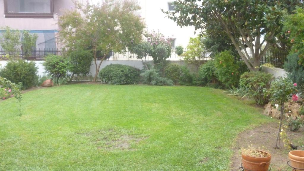 a yard with a green lawn with trees and bushes at Dream House in Iraklitsa