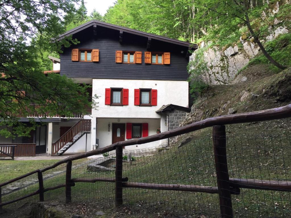 a black and white house with red shutters at alla curva del Pagliai in Abetone