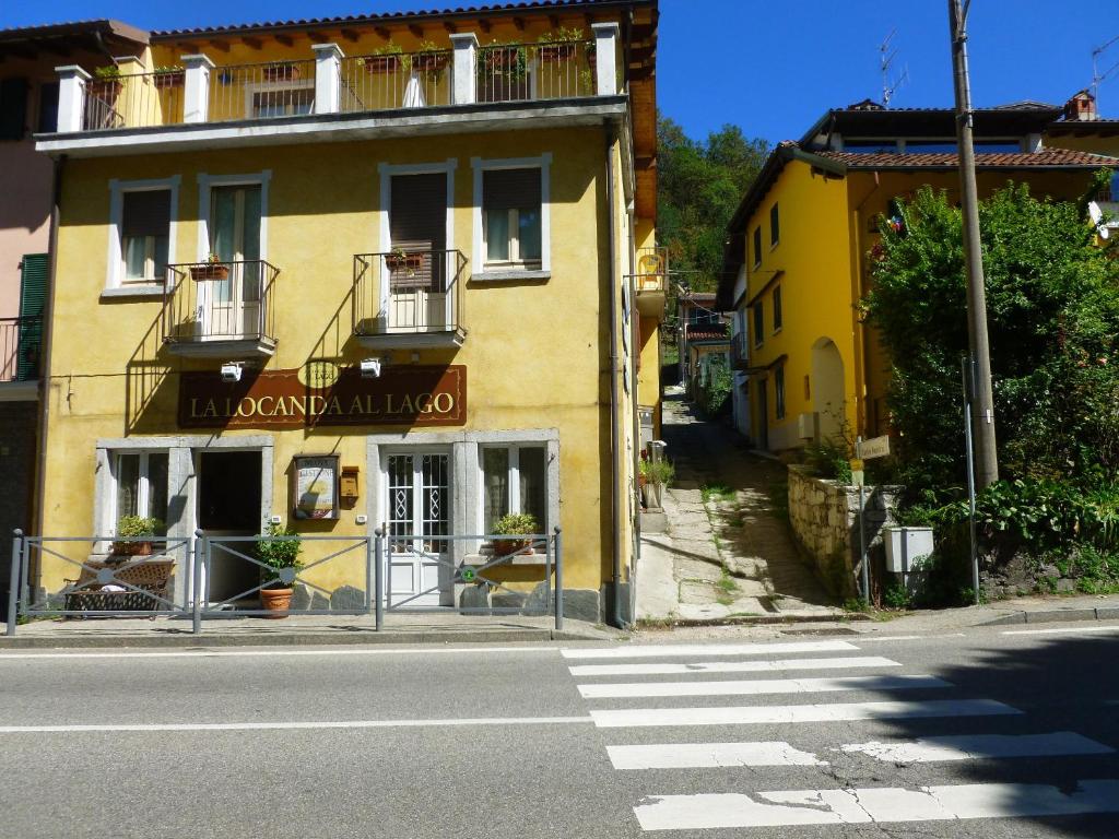 un bâtiment jaune sur le côté d'une rue dans l'établissement La Locanda Al Lago, à Verbania