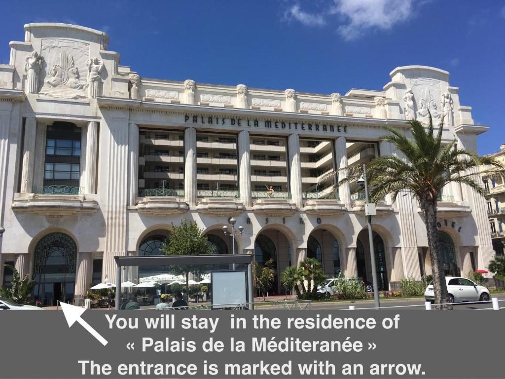 a large white building with an arrow in front of it at Quiet flat next to the beach in Nice