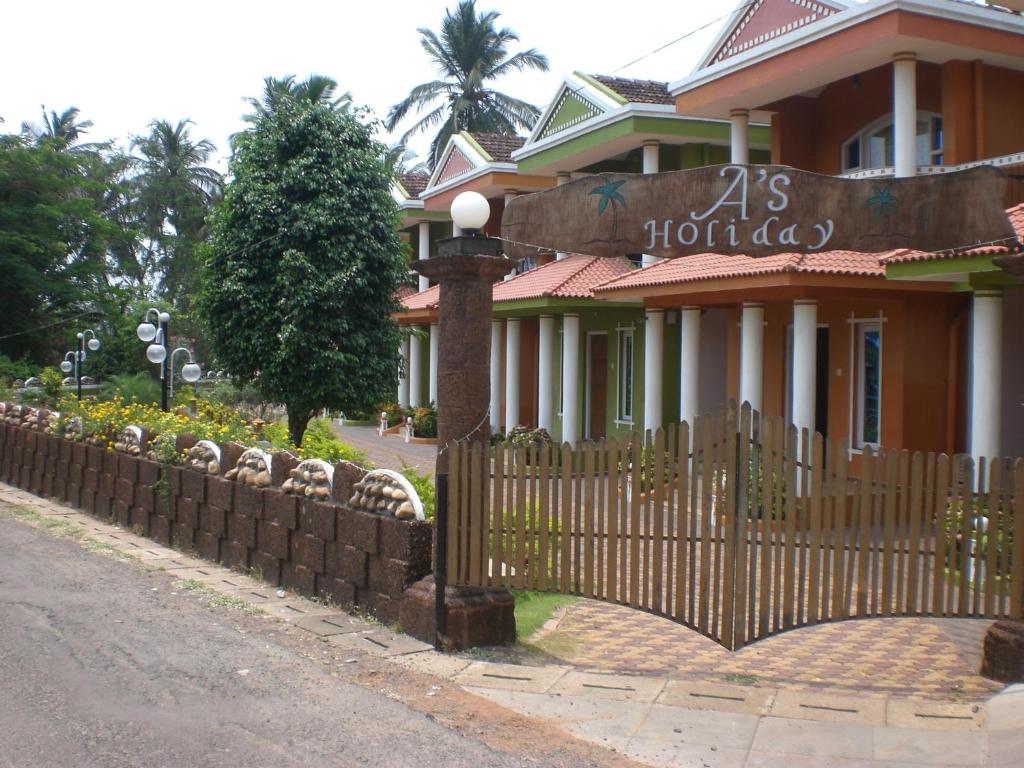 una cerca frente a una casa con una casa en A's Holiday Beach Resort en Betalbatim