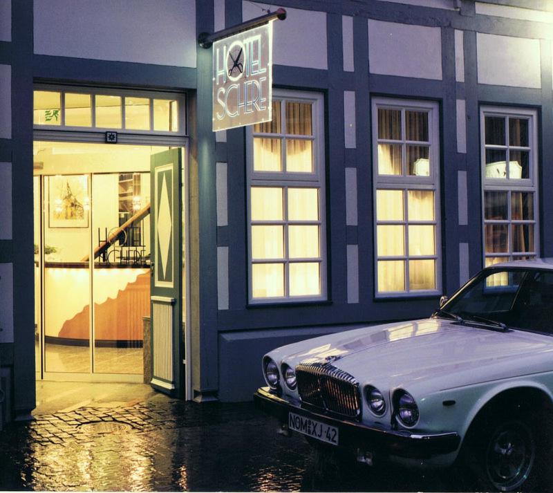 a white car parked in front of a building at Hotel Schere in Northeim