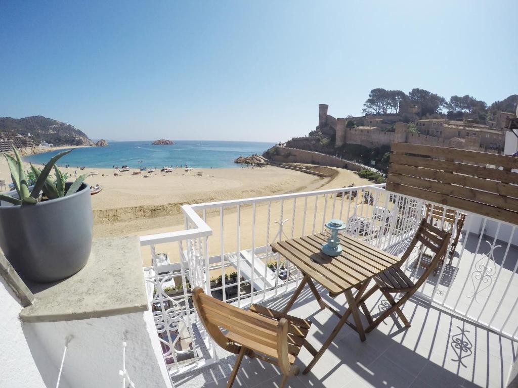 balkon ze stołem i krzesłami oraz plażą w obiekcie Hostal del Mar w Tossa de Mar