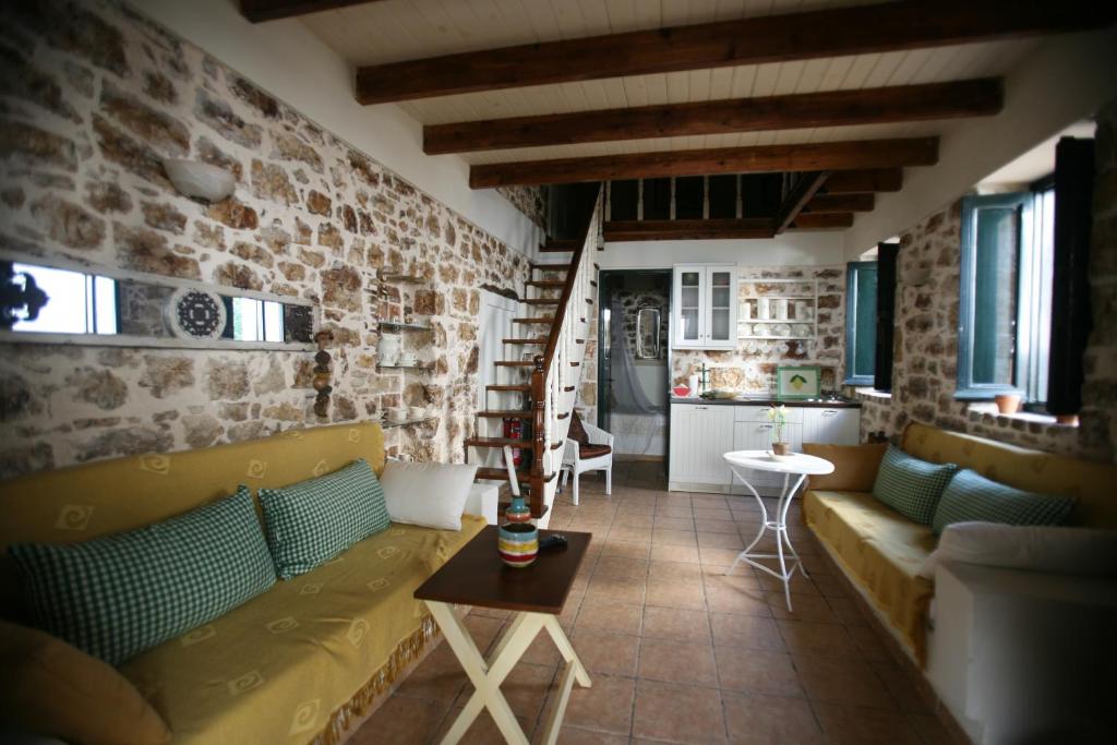 a living room with a couch and a brick wall at Christina's Stone Cottage in Kassiopi