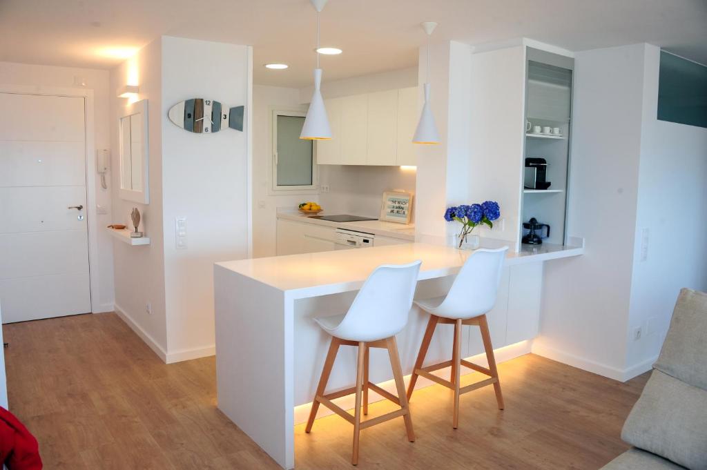 a kitchen with white counters and white cabinets at Apartamento frente al mar in Canet de Mar