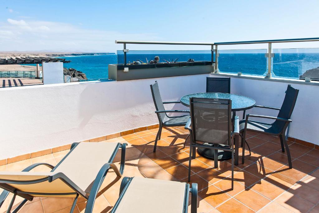 balcone con tavolo, sedie e vista sull'oceano di Apartamento Ocean Vista a Cotillo