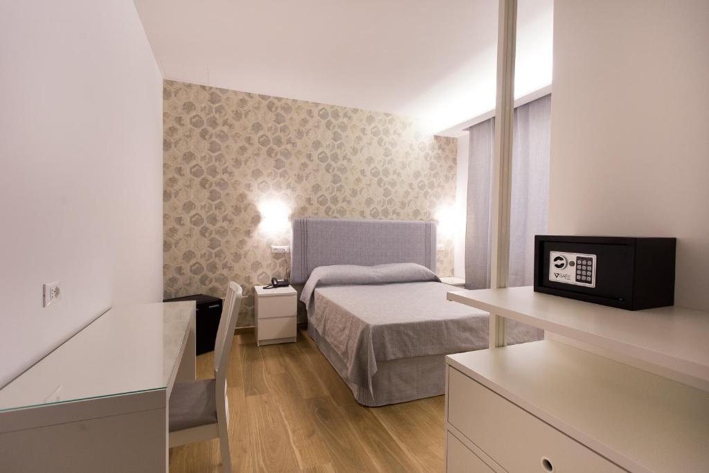 niewielka sypialnia z łóżkiem i biurkiem w obiekcie B&B Maria Rosaria w mieście Ladispoli