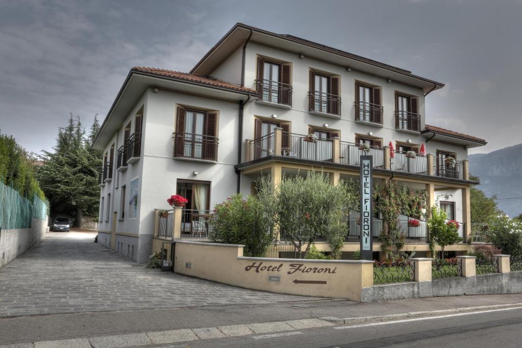 een wit gebouw met een bord ervoor bij Hotel Fioroni in Bellagio