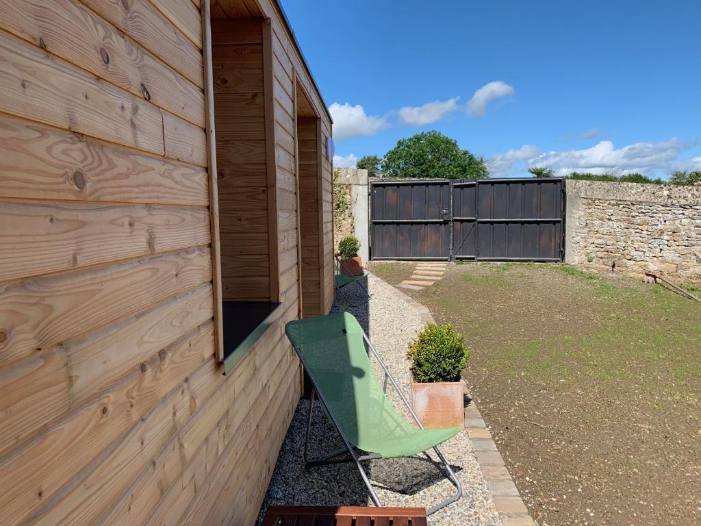 a green chair sitting on the side of a house at Villa kahlo Omaha Beach in Colleville-sur-Mer