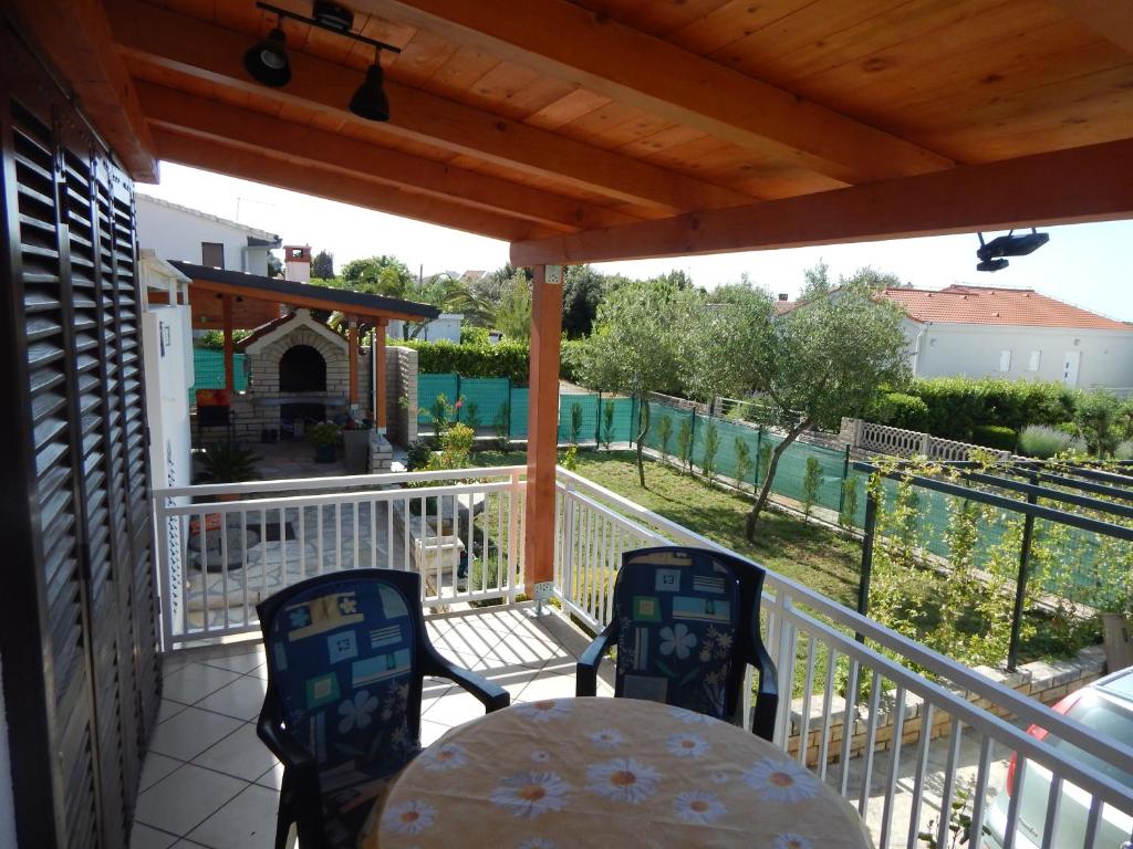 a patio with a table and chairs on a deck at Apartman Duje in Petrcane