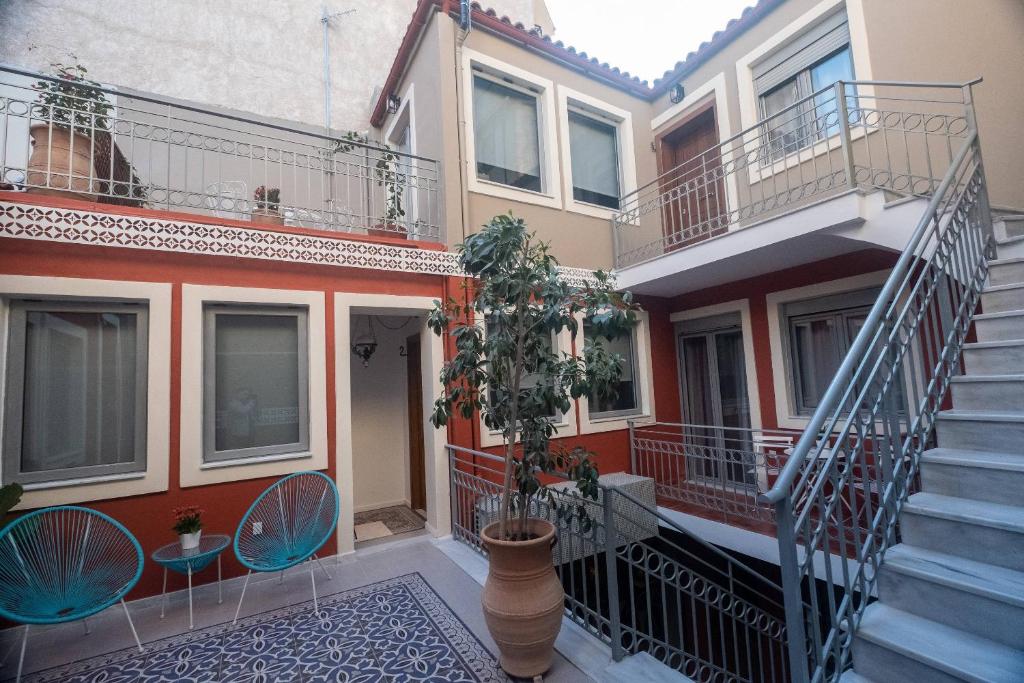 a house with stairs and a plant in a courtyard at ATHENIAN YARD SUITES in Athens