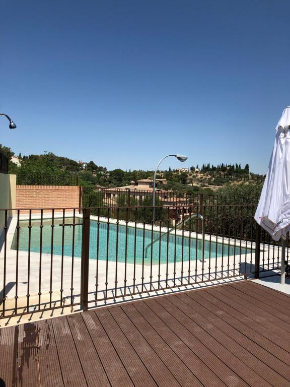 een hek met een zwembad voor een huis bij Hotel Los Cigarrales in Toledo