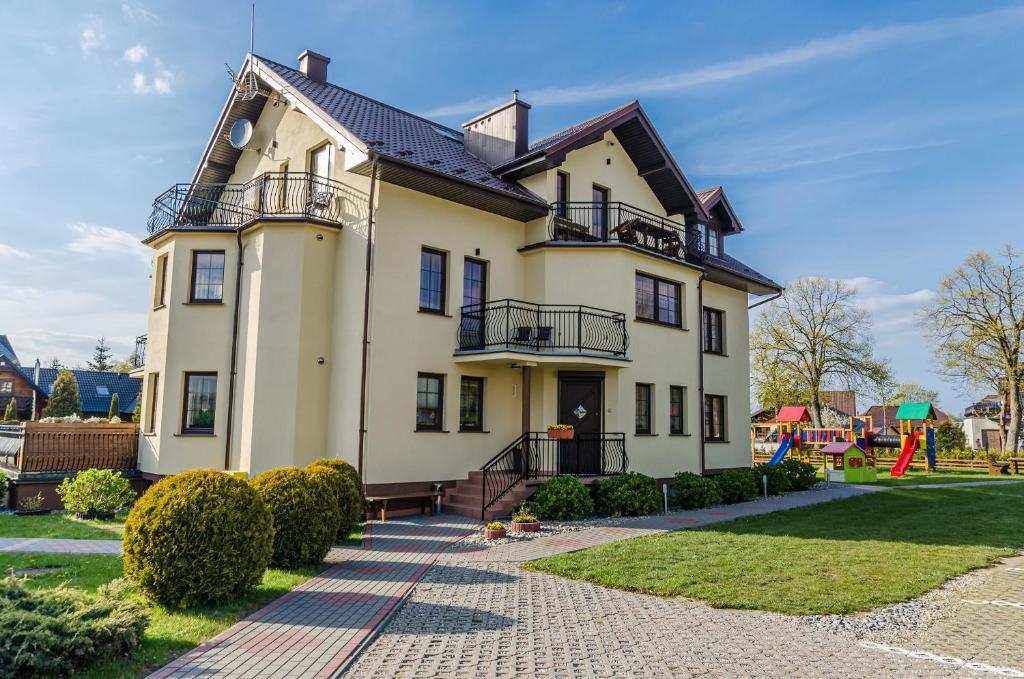a large house with a playground in front of it at Willa Pionier in Jastrzębia Góra
