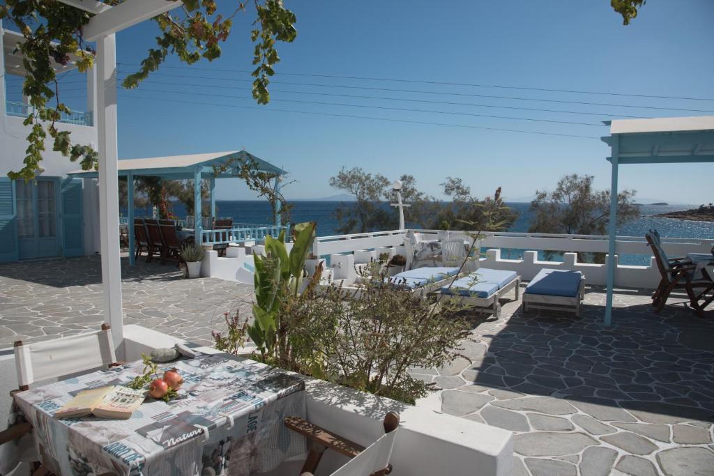 a patio with a table and chairs and the ocean at Paroscarmel studio-apartment in Logaras