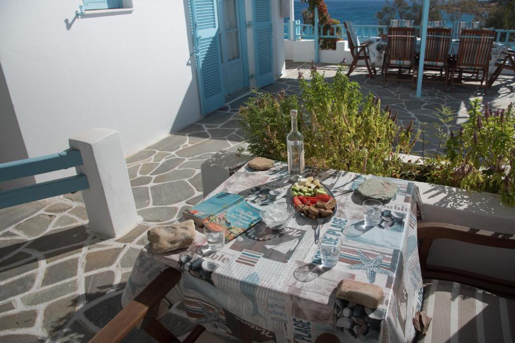 a table with a bottle of wine and a bowl of fruit at Paroscarmel studio-apartment in Logaras