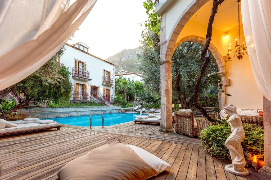 una terraza de madera con piscina y una casa en Jade Residence, en Ölüdeniz