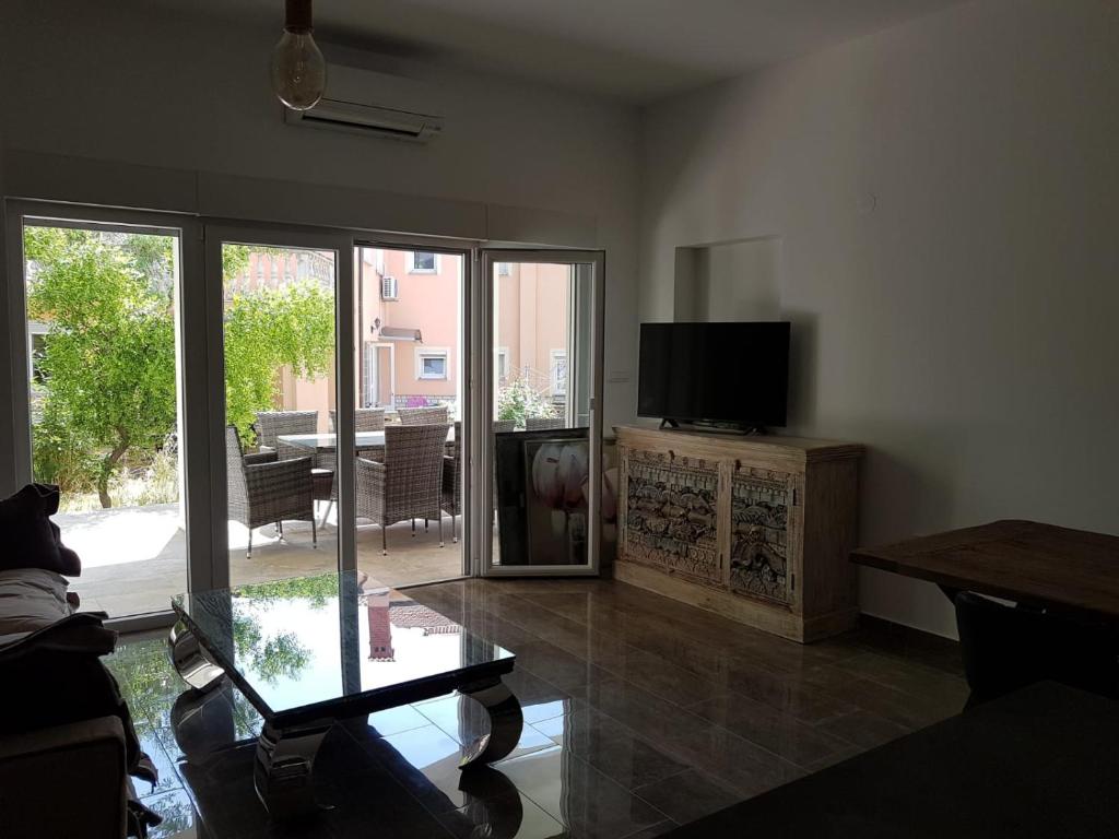 ein Wohnzimmer mit einem TV und einer Glasschiebetür in der Unterkunft Villa Iva in Medulin