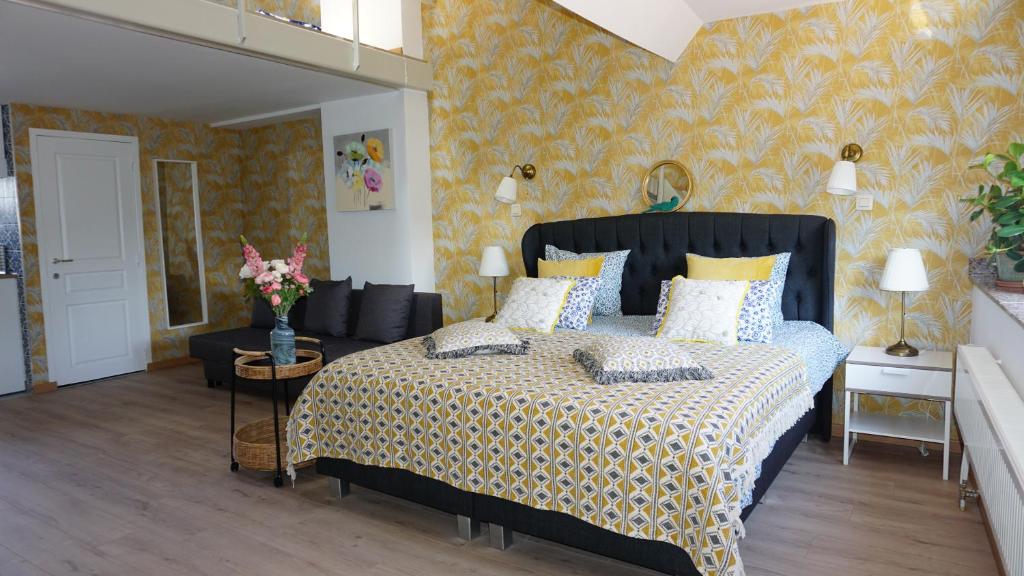 アントワープにあるSint-Jans Appartmentsのベッドルーム1室(黄色の壁紙の大型ベッド1台付)