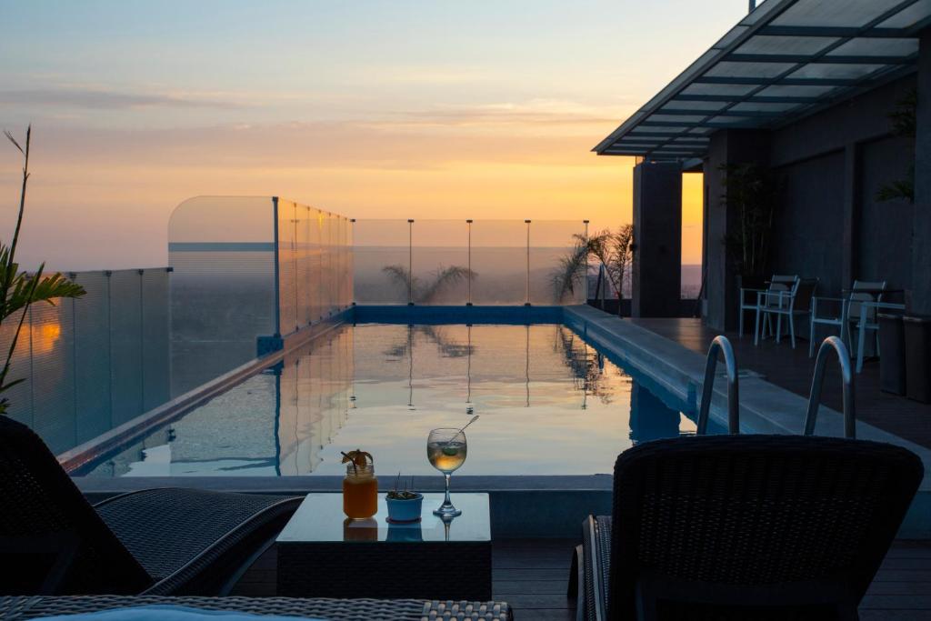 a swimming pool with a glass of wine on a building at Casa Andina Select Tacna in Tacna