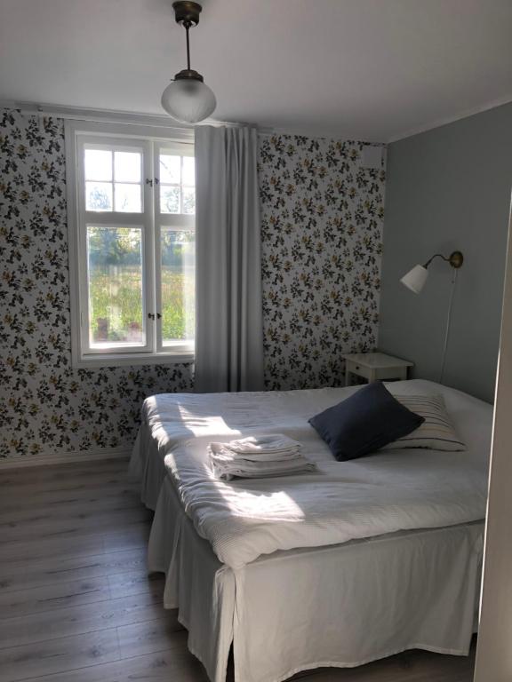 a bedroom with a large bed with a window at Pensionat Haga Öland in Löttorp