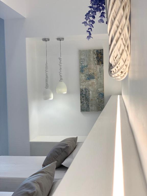 a white room with two pillows on a bed at Ios Art Suites in Ios Chora