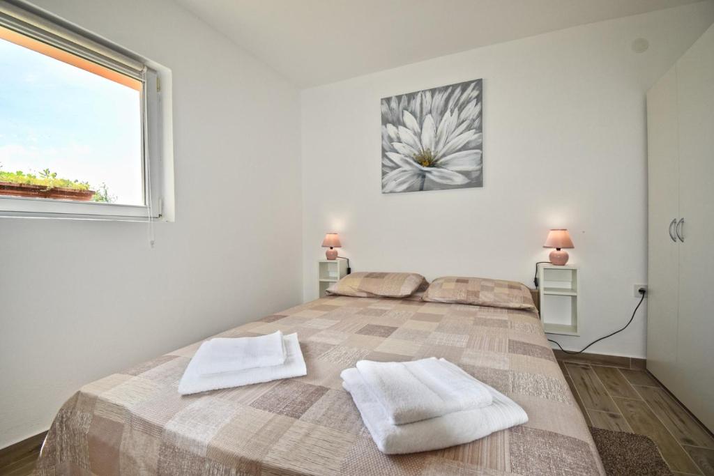 1 dormitorio con 1 cama grande y 2 toallas. en New apartment with lovely terrace and swing, en Loborika