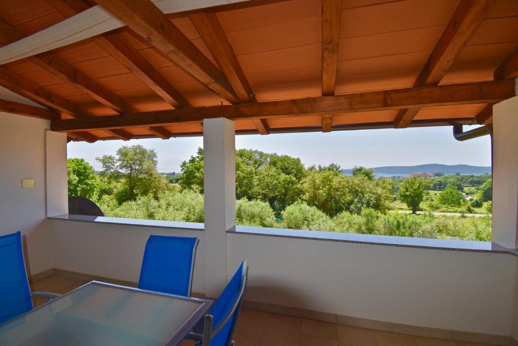een eetkamer met een tafel en stoelen en een groot raam bij Relaxing holiday house with terrace sea view in Medulin