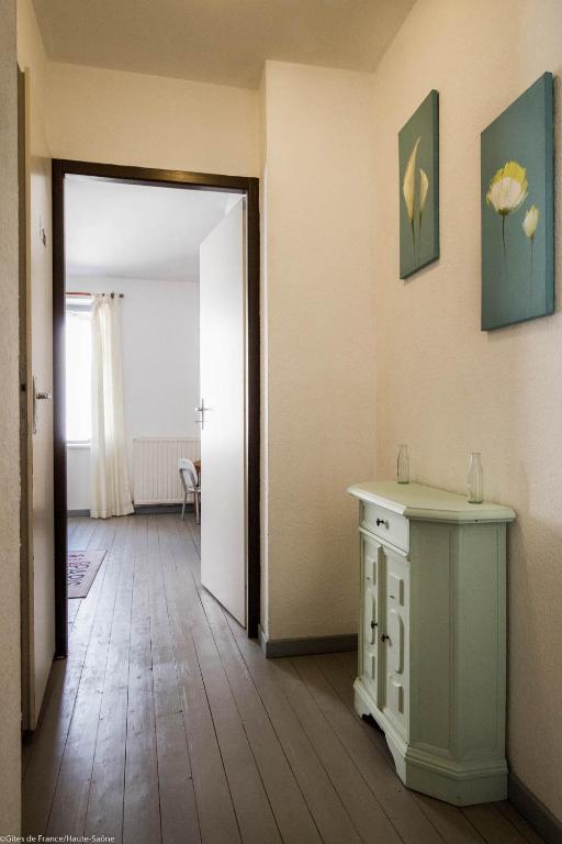 Cette chambre dispose d&#39;un couloir avec une table et une porte. dans l&#39;établissement Gîte La Saônoise, à Conflandey