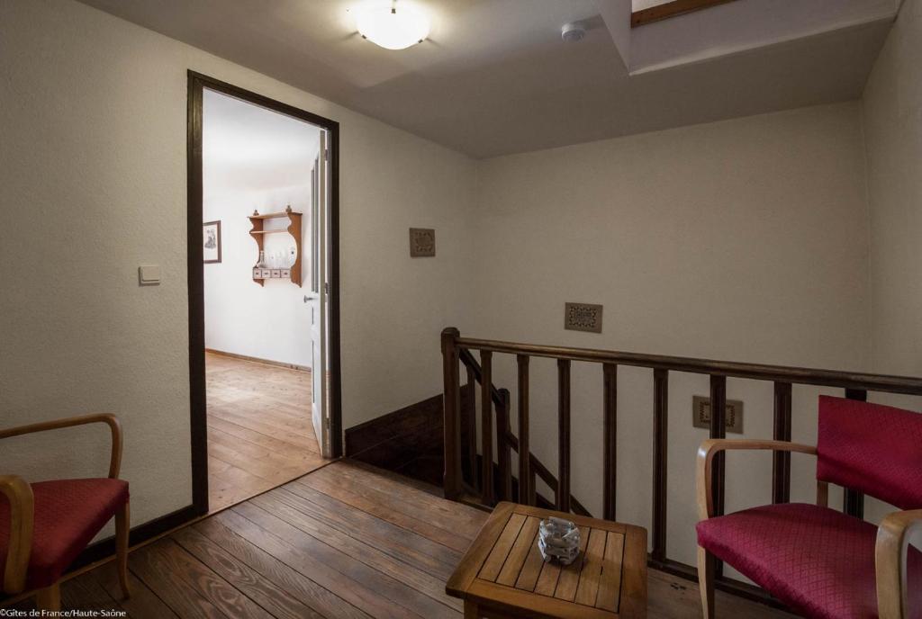 Cette chambre dispose d&#39;un escalier avec deux chaises et une table. dans l&#39;établissement Gîte La Saônoise, à Conflandey