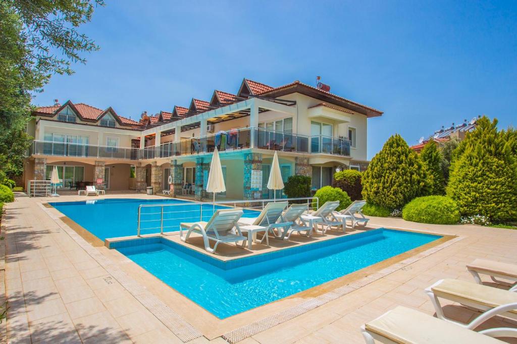 a large house with a swimming pool in front of it at Number 8 Olivia Apartments in Oludeniz