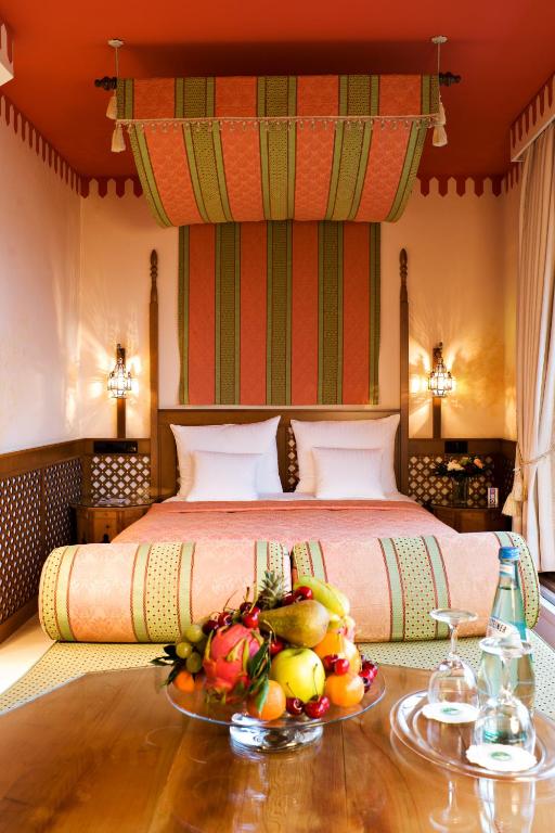 a bedroom with a bed with a bowl of fruit on a table at Hotel Parc Belair in Luxembourg