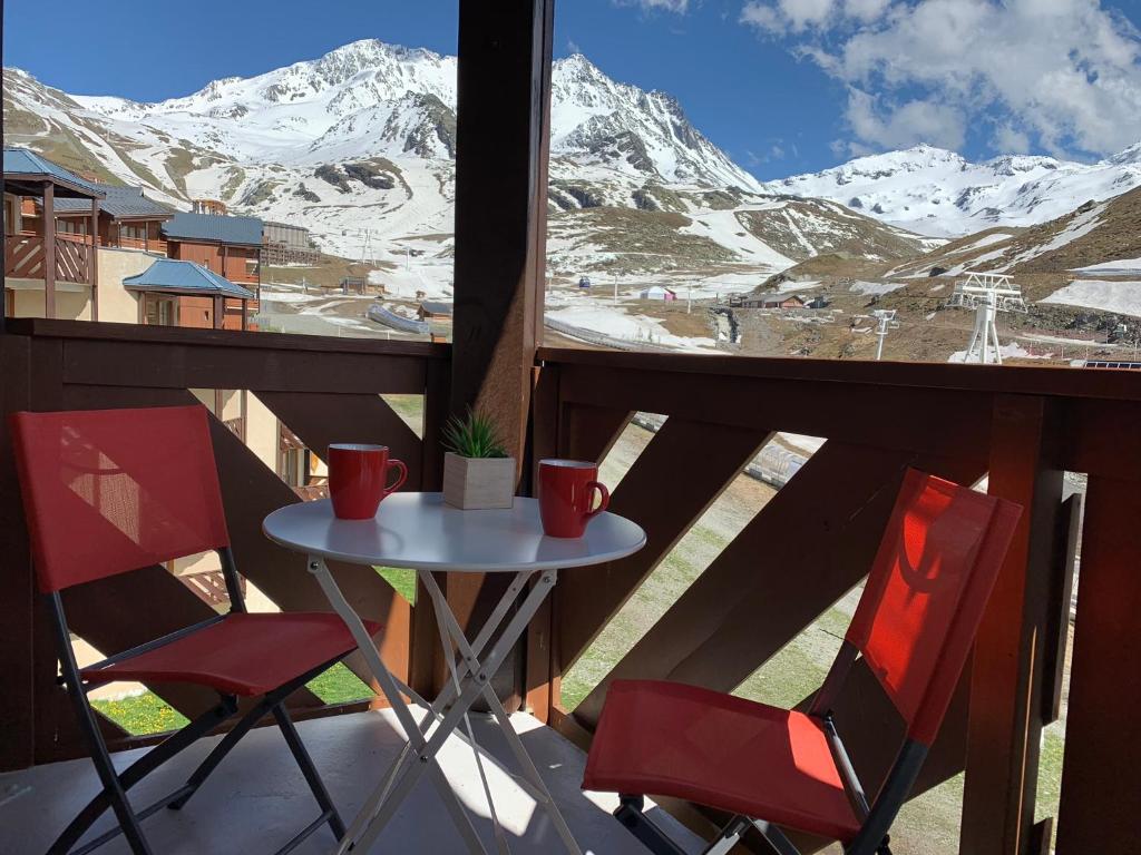 ヴァル・トランスにあるVal Thorens Temple of the Sun - ski in, ski outの雪に覆われた山々の景色を望むバルコニー(テーブル、椅子2脚付)