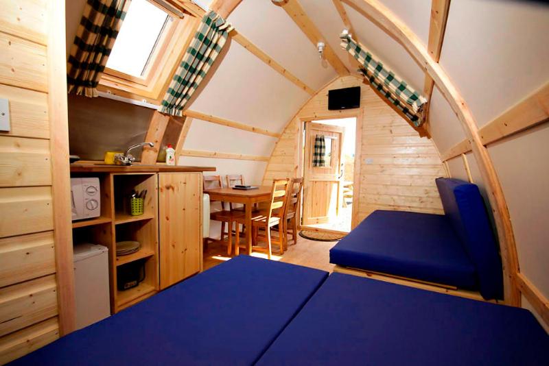 a small room with a blue bed in a house at Causeway Coast Wigwams in Bushmills