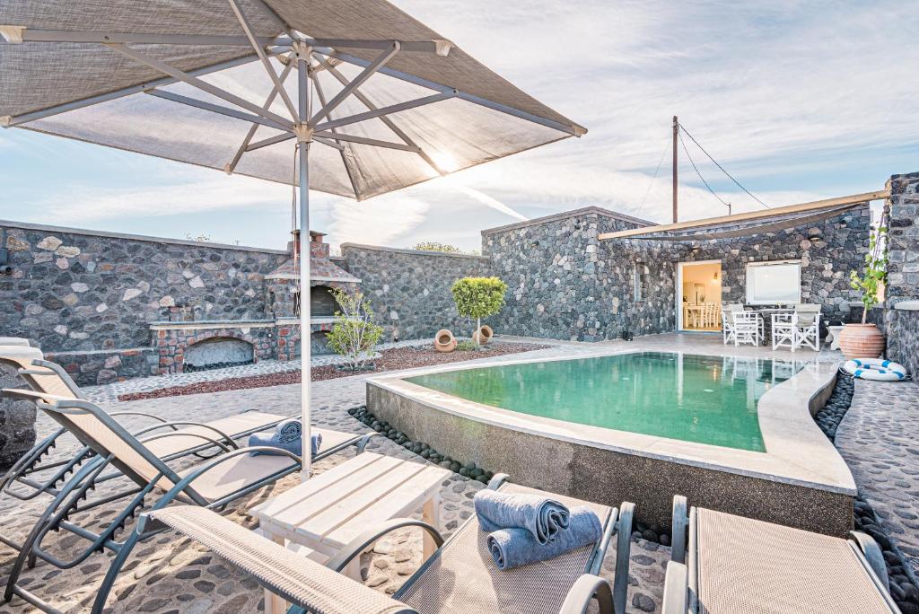 - une piscine avec des chaises et un parasol dans l'établissement Klimata House - Private Jacuzzi Pool & BBQ Villa, à Vlychada Beach