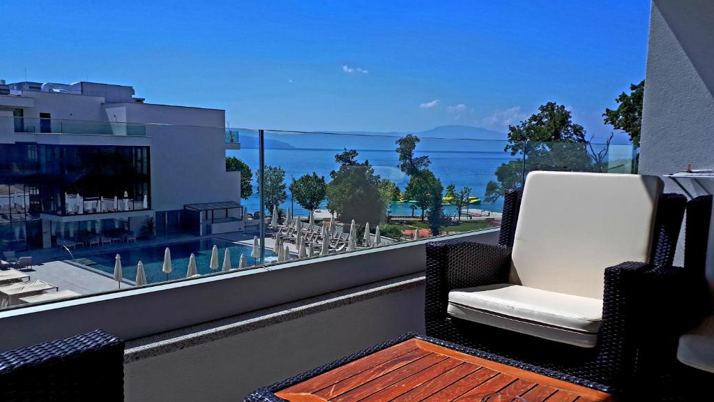 a balcony with a chair and a view of the ocean at Apartment Villa Vala in Malinska