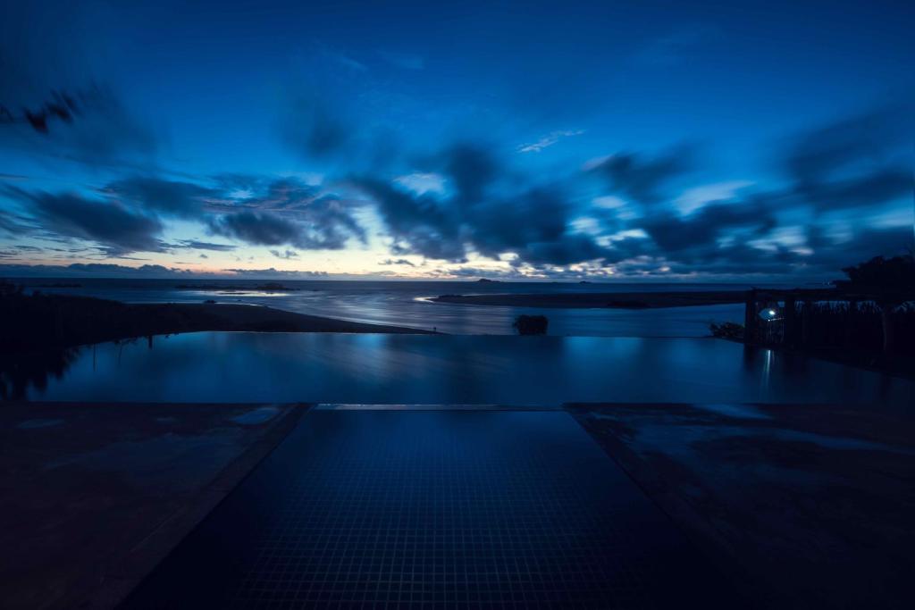 a view of a pool at dusk with a cloudy sky at C Beyond Nilaveli in Nilaveli
