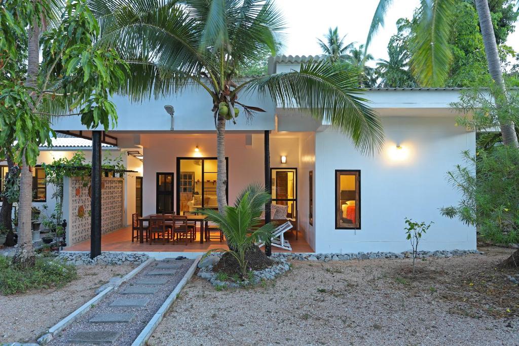 a house with a palm tree in front of it at 155 SalaCoco in Ban Krut